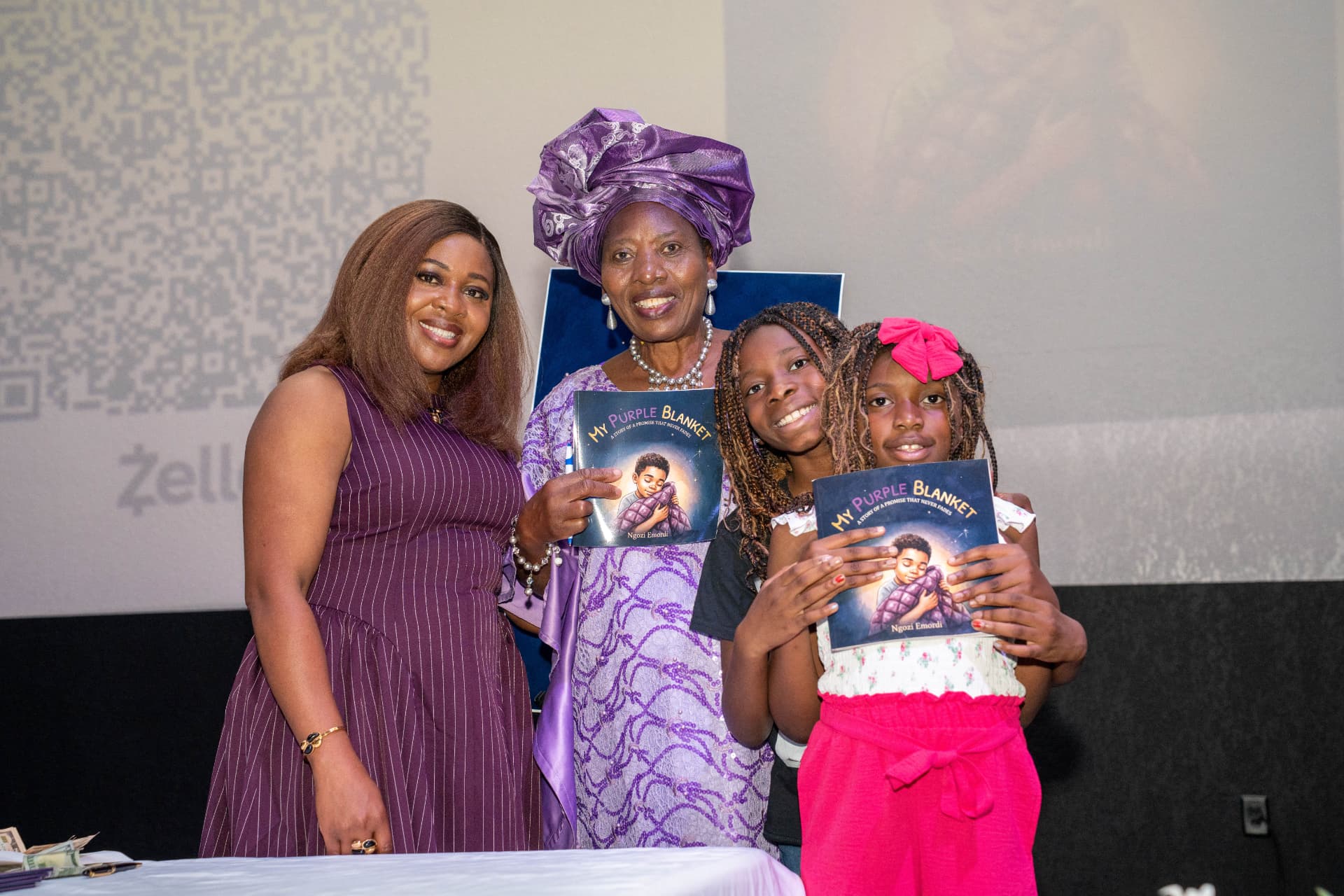 Ngozi with a grandmother and children holding My Purple Blanket